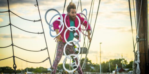 Cirkusartist som jonglerar med ringar och glasflaskor.